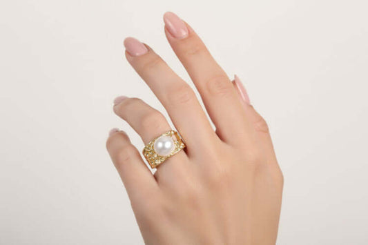 Golden Tide Pearl Ring on a woman's hand showcasing the hammered gold design and lustrous freshwater pearl.
