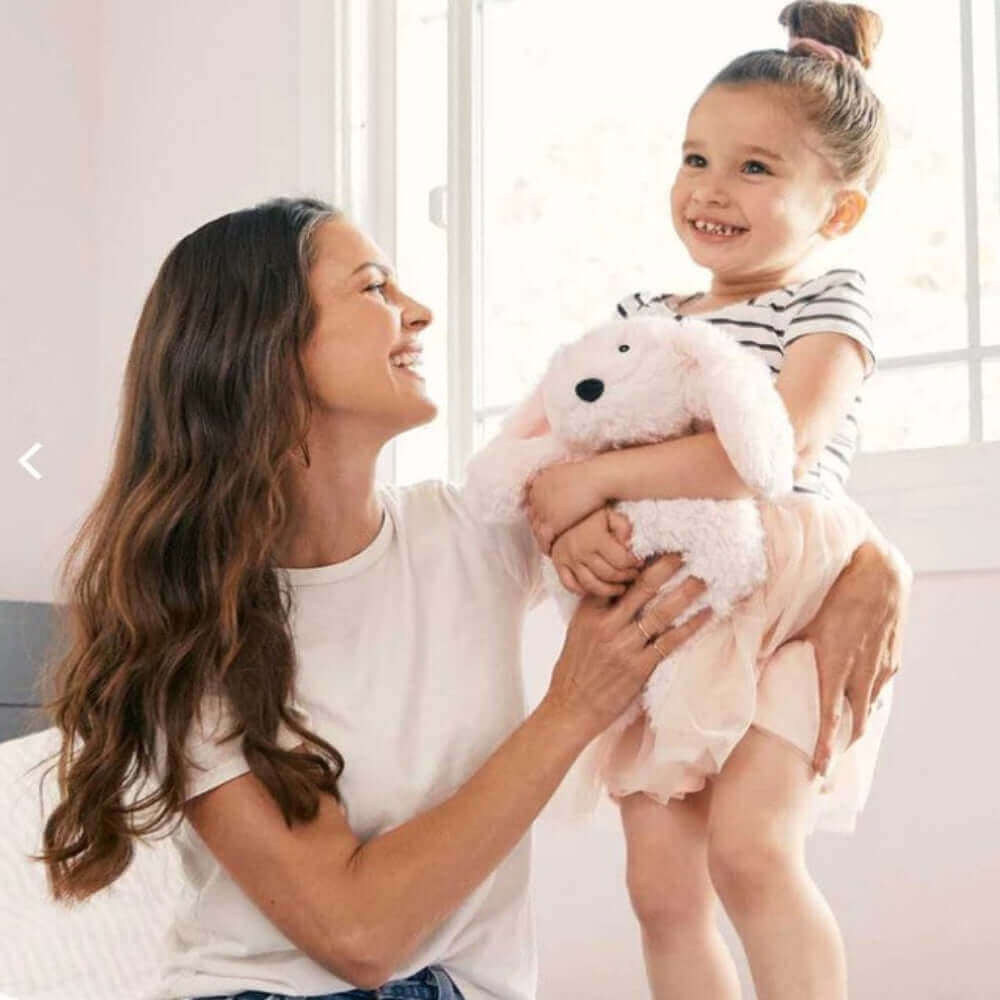 Mom and daughter enjoying time together with Pink Bunny Warmies, a plush lavender-scented therapy toy.
