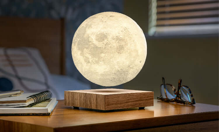 Moon-shaped lamp on a wooden base in a bedroom setting