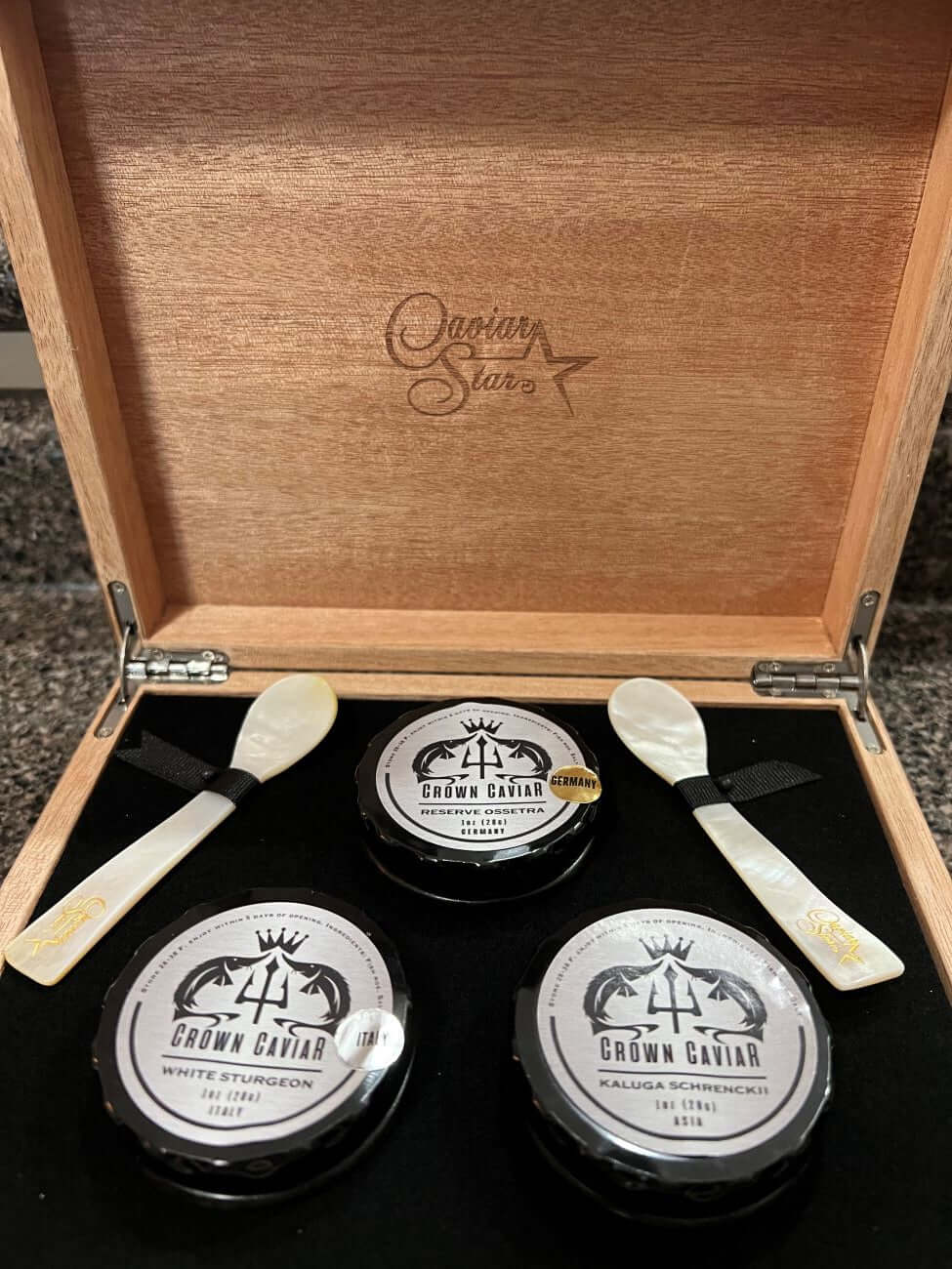 Luxury caviar gift box featuring three 1 oz tins of Crown Caviar and two spoons in a mahogany case.