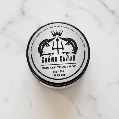 A tin can labeled 'Crown Caviar Smoked Trout Roe' with a graphic of a trident and fish, indicating the product is a gourmet delicacy.