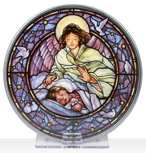 A round stained glass window featuring a depiction of a guardian angel with a sleeping child, designed by Randy Wollenmann.