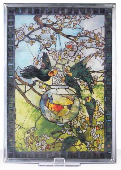 A piece of stained glass artwork featuring birds and fish with a colorful, intricate design.