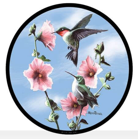 A round stained glass panel featuring a vibrant depiction of two hummingbirds in flight, feeding on pink flowers against a blue sky background.