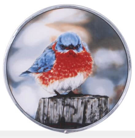 Stained glass art roundel featuring a blue bird with fluff-feathered wings perched on a wooden post.