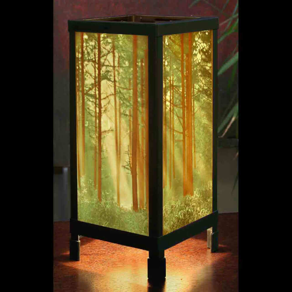 Lithophane porcelain artwork lighting featuring a forest scene lamp casting a warm glow.