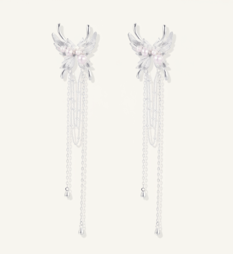 Elegant silver-plated drop earrings with wing-shaped tops, white pearl accents, and long chain tassels on white background.