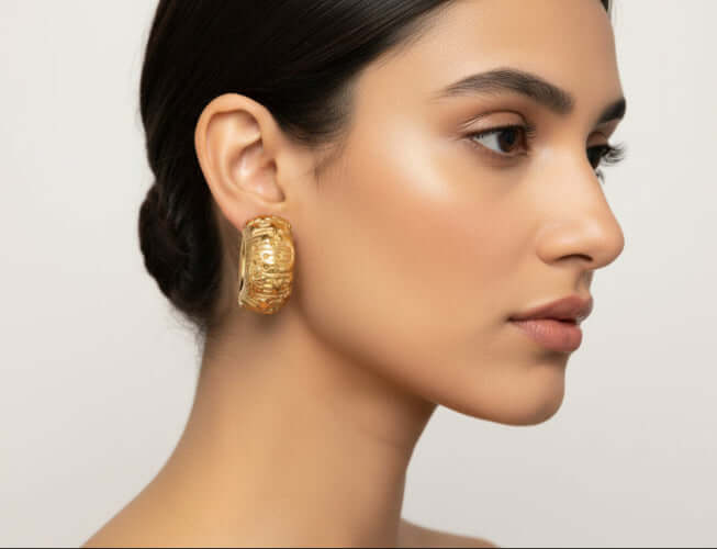 Model showcasing Celestial Dreams Hoops earrings with sun and star engravings, highlighting confidence and warmth.