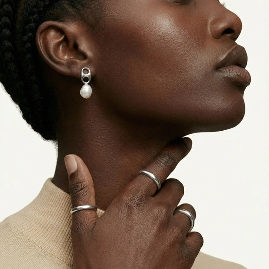 Model wearing Pearl Circle Drop Studs earrings with silver geometric design and pearl detail.