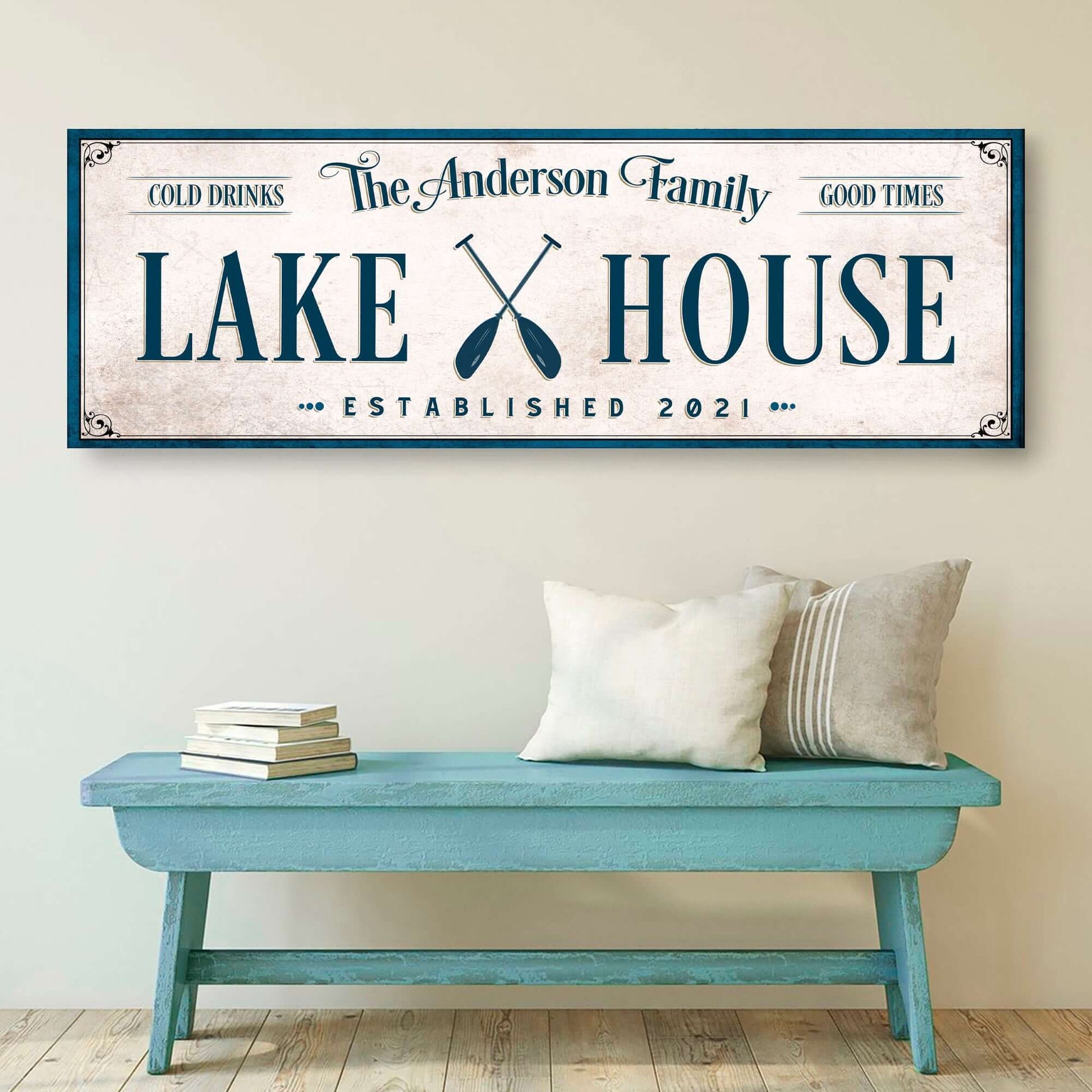 Personalized Lake House Sign IV displayed on a wall above a blue bench with cushions, showcasing family name and established date.