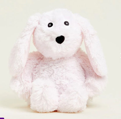 A pink plush bunny-shaped warmie with a face printed on its side, designed for microwave and freezer use.