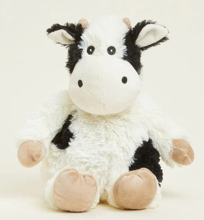 A plush toy resembling a black and white cow with a soft texture, designed to be microwavable and scented with lavender.