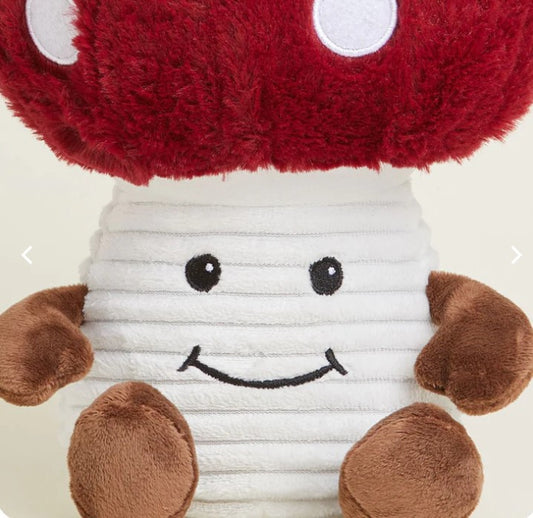A plush toy resembling a smiling mushroom with a red cap, white stem, and brown spots.