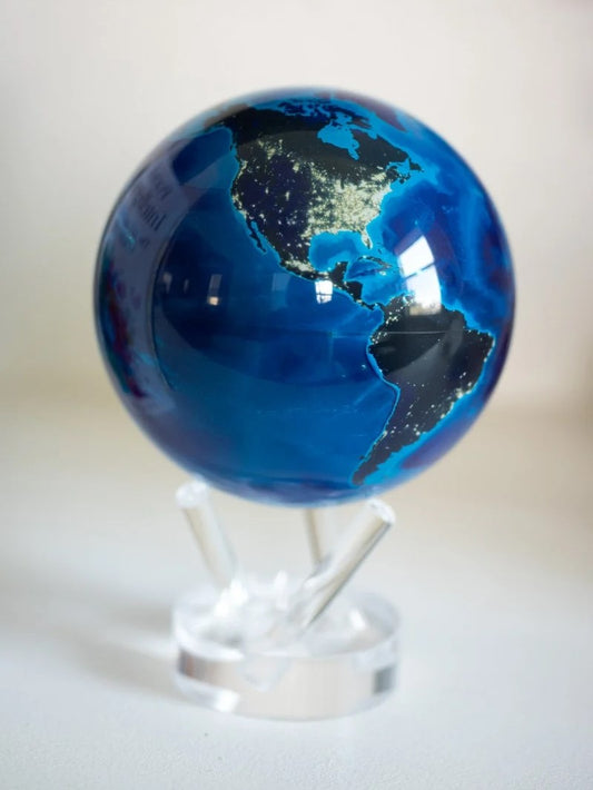 A rotating Earth globe at night, featuring illuminated cities from NASA satellite images, displayed on a clear stand.