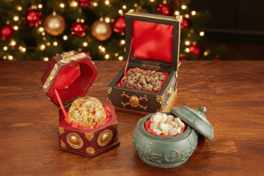 Decorative boxes with gold and red accents on a wooden surface with a festive background.