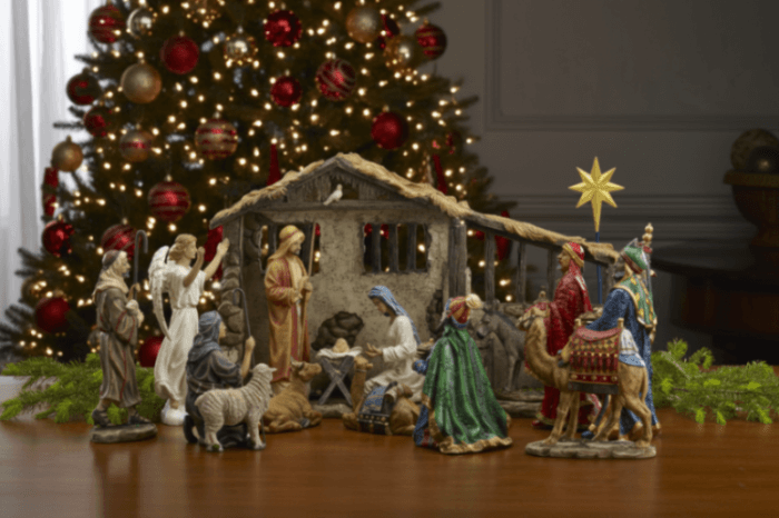 Nativity scene with figures in front of a decorated Christmas tree