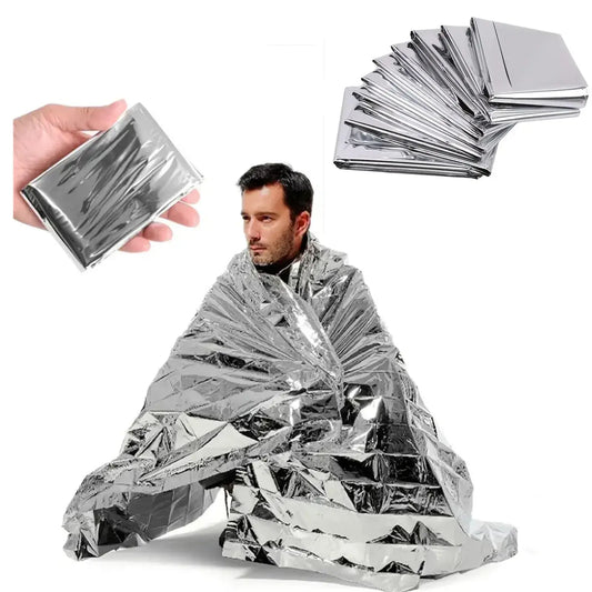 Emergency Solar Blanket for Hunting or Camping shown on a person staying warm with multiple blankets in the background.