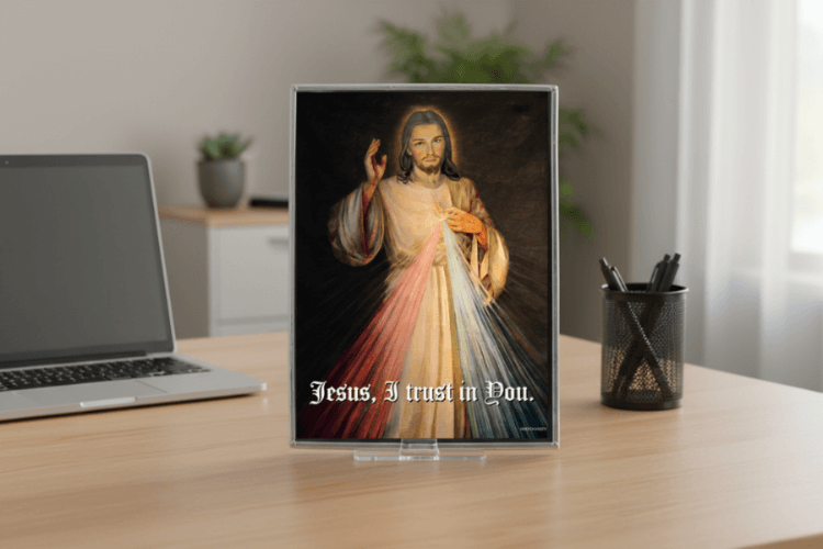 Tablet displaying an image of a religious figure with 'Jesus, I trust in You.' text on a desk.