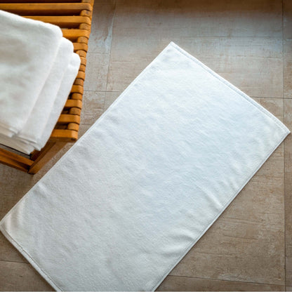 Luxury organic bath mats displayed on a bathroom floor, showcasing soft, absorbent Turkish organic cotton.