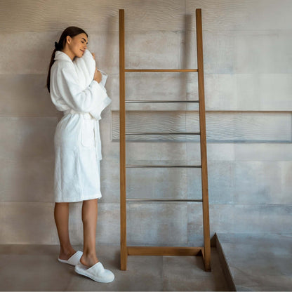 Luxury organic bathrobe and slippers set in a cozy home setting with a woman enjoying comfort.