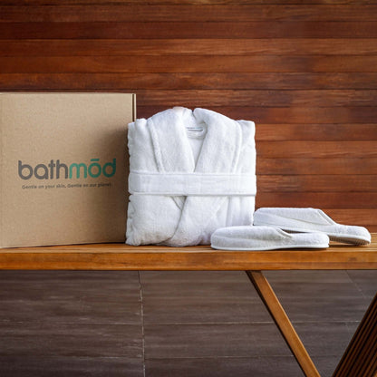 Luxury organic bathrobe and slipper set displayed on a wooden table beside its eco-friendly packaging.