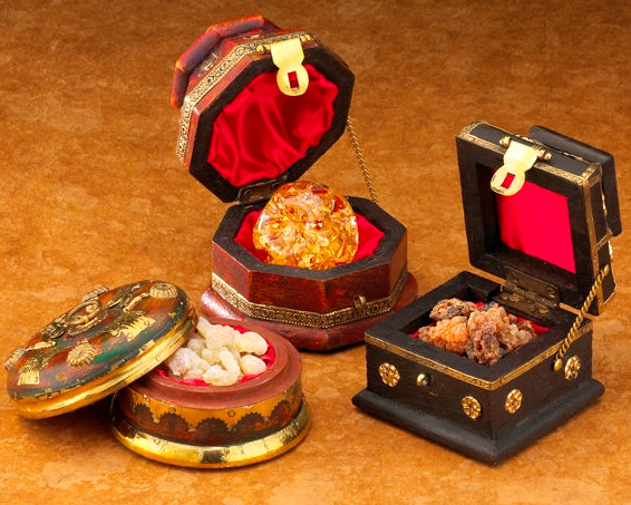 Three handcrafted wooden chests with brass accents, containing gold flakes in a glass globe, and myrrh, intended for use with nativity sets.