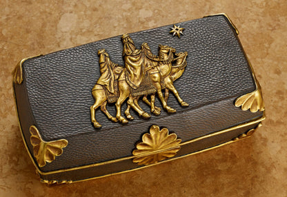 A Regal Music Box with a 23K gold detail depicting the Magi following the Christmas Star on the lid, set against a textured background.