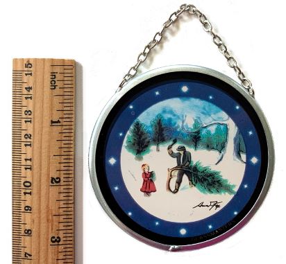 A 3-inch round stained glass ornament featuring a classic winter tree cutting scene with a man, a girl, in a snowy field, with a blue night sky adorned with stars and a crescent moon.